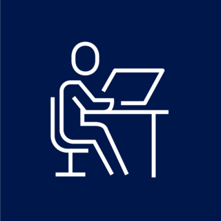 Das Icon zeigt eine stilisierte Person, die an einem Schreibtisch sitzt und an einem Laptop arbeitet.